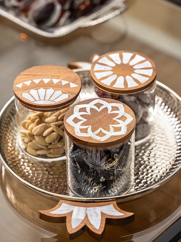 Three mother of pearl storage jars filled with candies and nuts