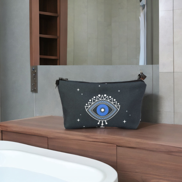 A black star bag with evil eye styling on a bedroom counter.