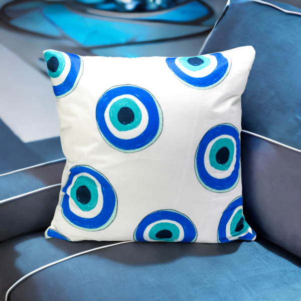 A blue and white Malda Cushion with an evil eye on it.