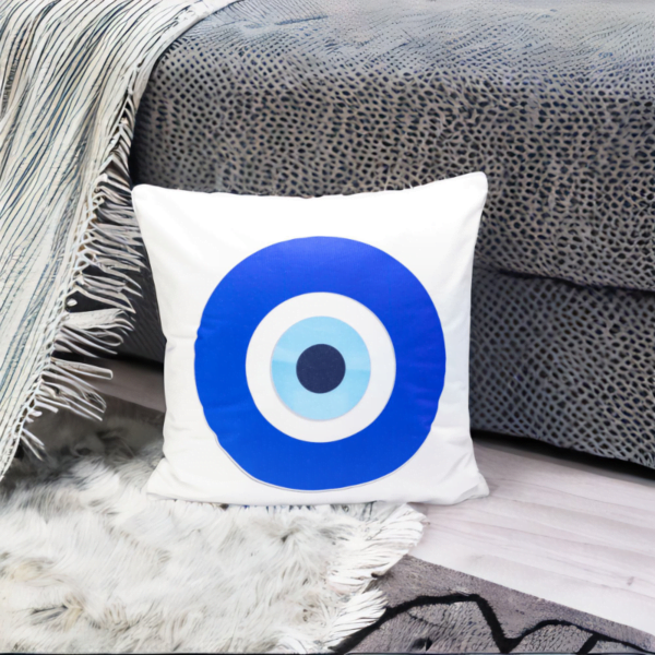 the hiba cushion, a white and plump cushion adorned with artistic blue and white evil eye imagery.