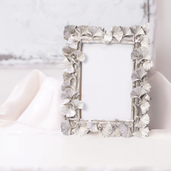 Silver frame with intricate leaf design. Perfect for displaying cherished memories.
