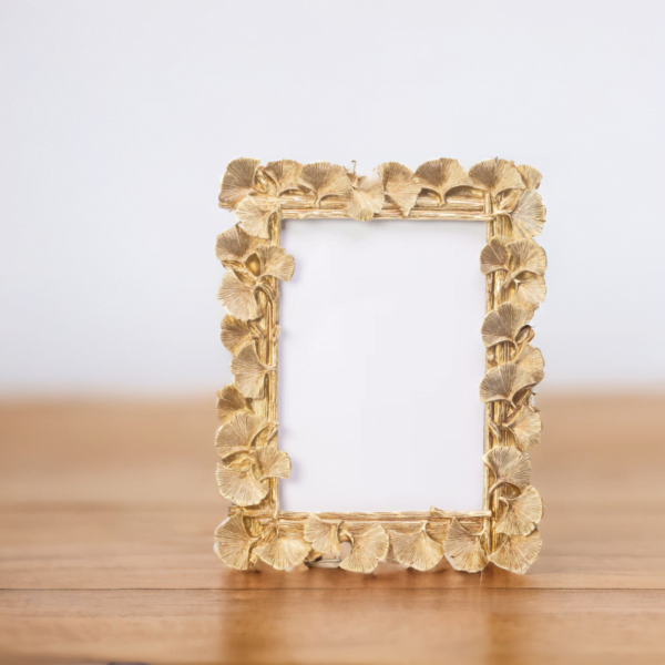 A Laura Gold Frame on a wooden table in London.