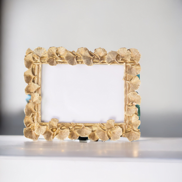 A Laura Gold Landscape Frame on a white table.