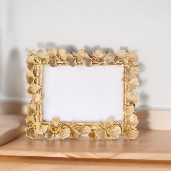 A Laura Gold Frame sitting on a shelf.