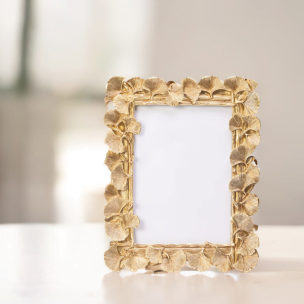 A gold frame adorned with delicate leaves, adding an elegant touch to any artwork or photograph.