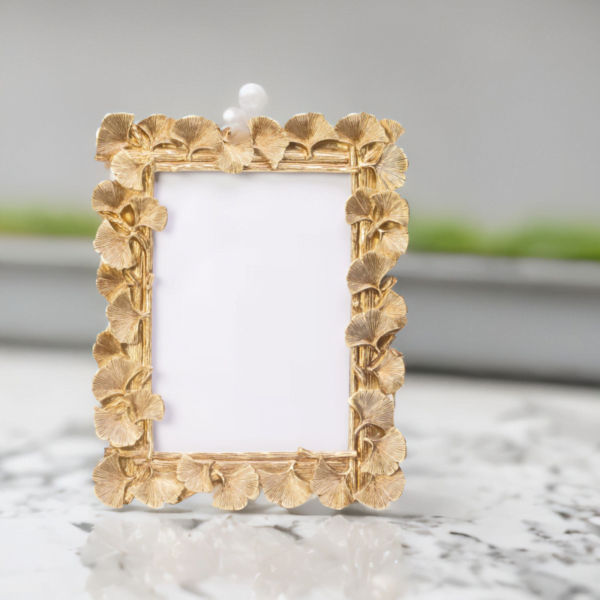 A Laura Gold Photo Frame on a marble table.