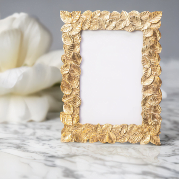 A Gold Leaf Photo Frame on a marble table.