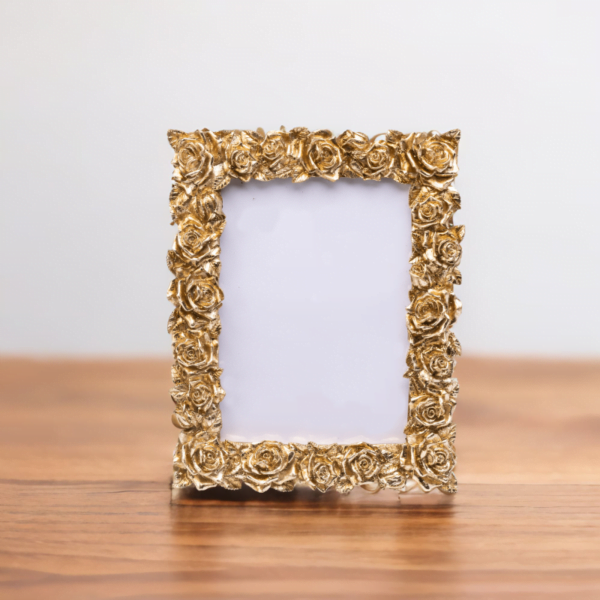 A Floral Gold Frame on a wooden table.