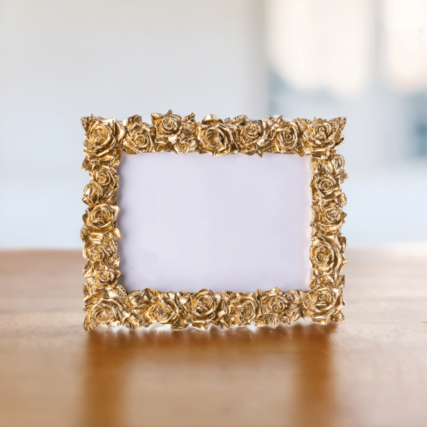 A Floral Gold Frame picture frame on a wooden table.