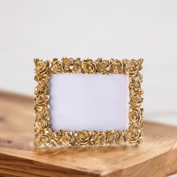 A gold rose photo frame on wooden table in living room