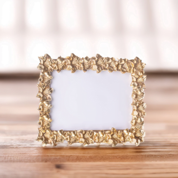 A gold frame adorned with delicate leaves, adding an elegant touch to any artwork or photograph.