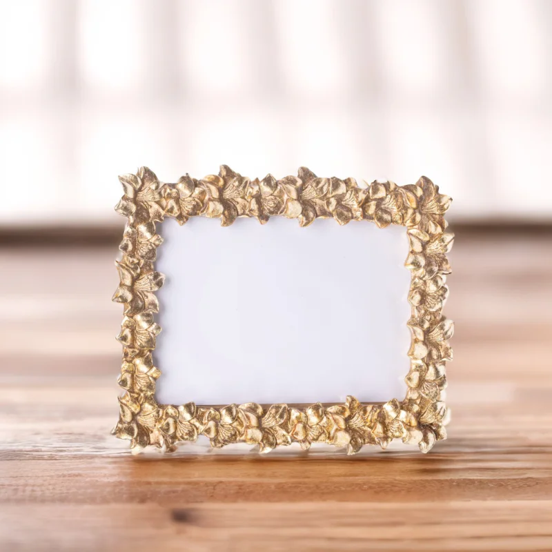 A gold frame adorned with delicate leaves, adding an elegant touch to any artwork or photograph.