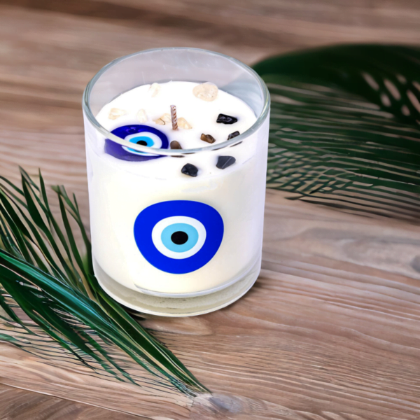 An Evil Eye Cotton Flower Candle sits on a wooden table.