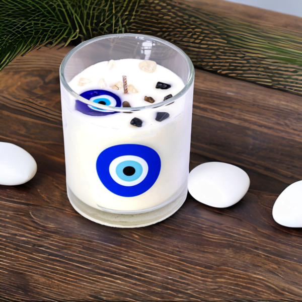 An Evil Eye Luxury Sandalwood Musk Candle sits on a wooden table.