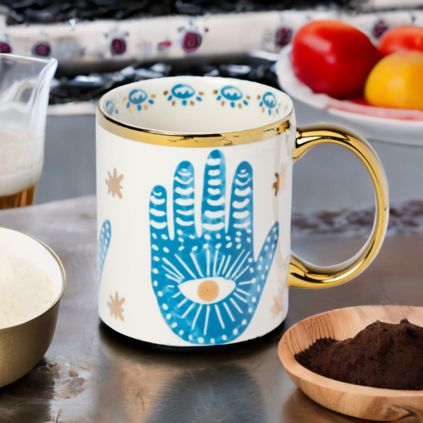 A blue and white Hamsa Hand Mug with gold accents.