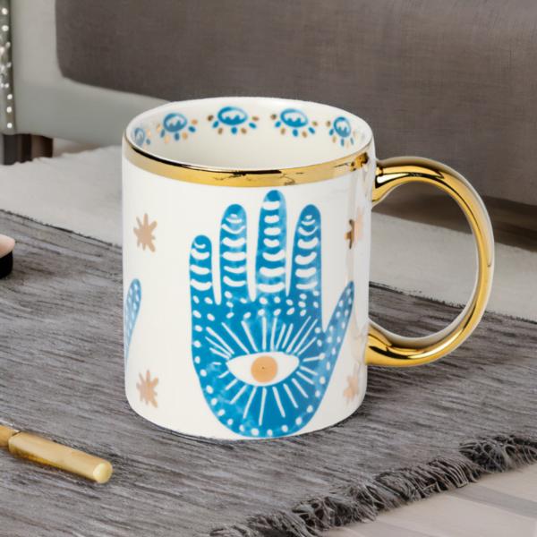 A blue and gold Hamsa Hand mug with a Hamsa hand print on it.