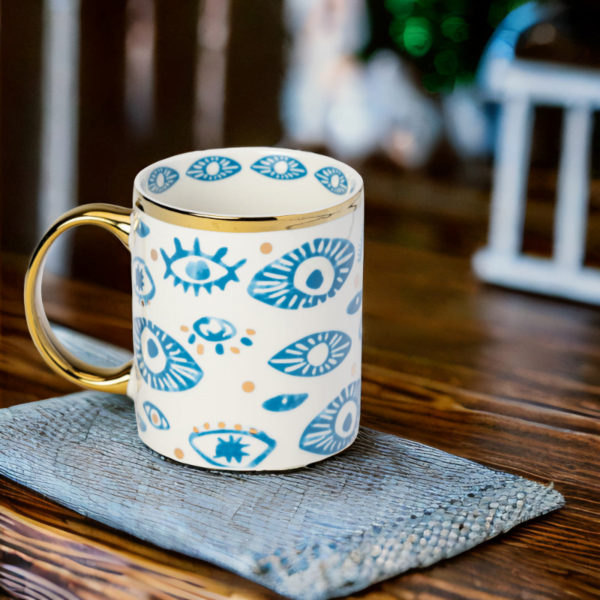 An Evil Eye Mug with a blue and gold pattern on it.