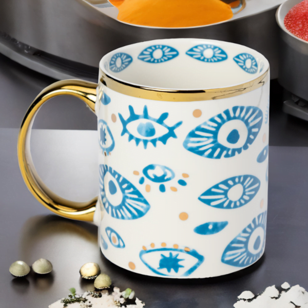 Blue and White Mug with Evil Eye Styling and Gold Accents on a Table in London.