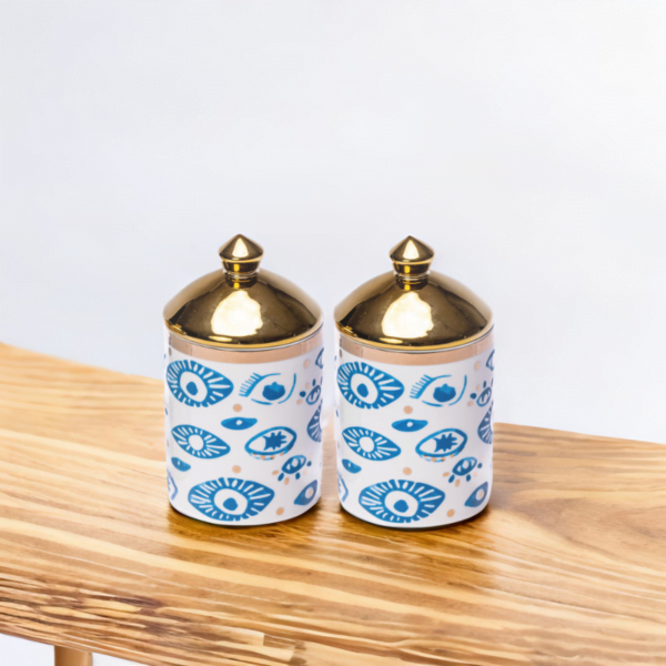 A Decorative Set of Evil Eye Canisters (Set of 2) on a wooden table.