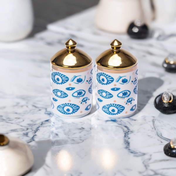 Two Evil Eye Decorative Canisters (Set of 2) on a marble table.