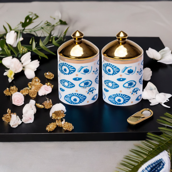 Two Evil Eye Canisters (Set of 2) with flowers on a tray.