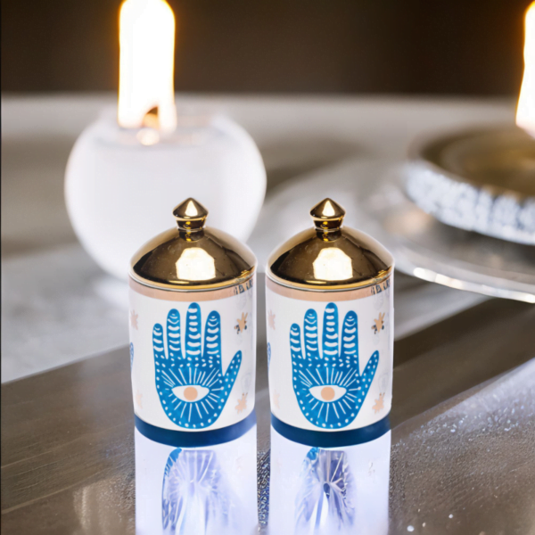 Two Hamsa Hand Canisters (Set of 2) with a candle in them.