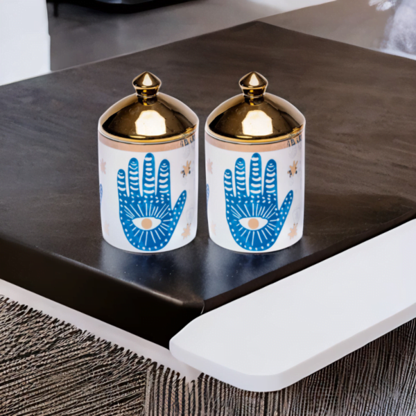 A set of two decorative canisters with hamsa hand styling.