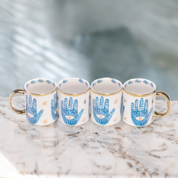 4 matching Hamsa hand mugs on marble top.