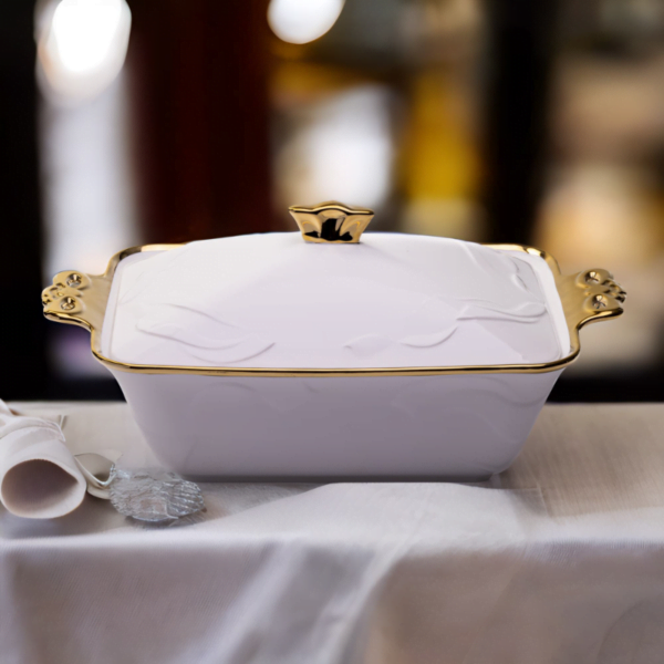 A white and gold Deep Ceramic Serving Plate on a table.