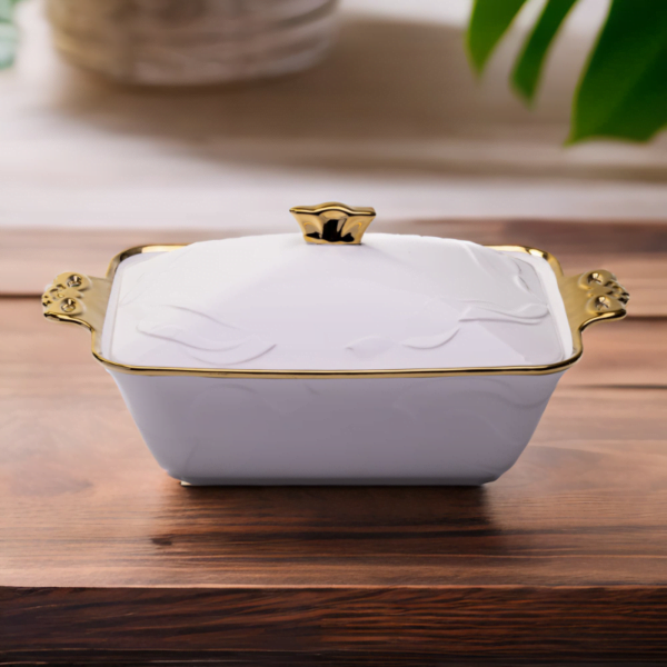 A Deep Ceramic Serving Plate with gold trim on a wooden table.