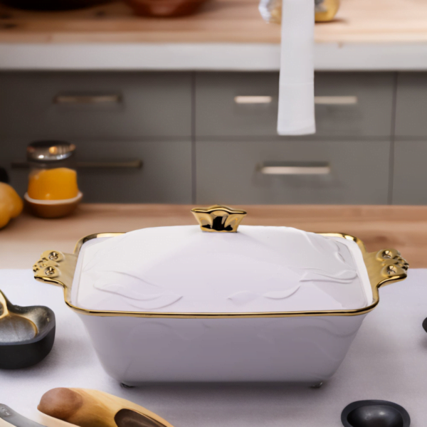 A white and gold Deep Ceramic Serving Plate on a kitchen counter.