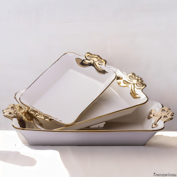 A set of three Deep Serving Ceramic white and gold serving dishes on a table.