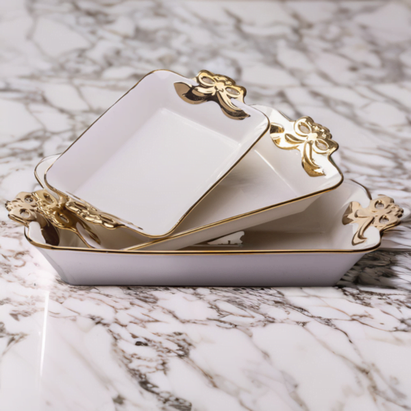 a set of three Deep Serving Ceramic dishes with gold trim on a marble surface.