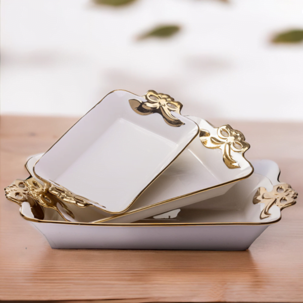 a set of three luxury Deep Serving Ceramic white and gold serving dishes on a wooden table.