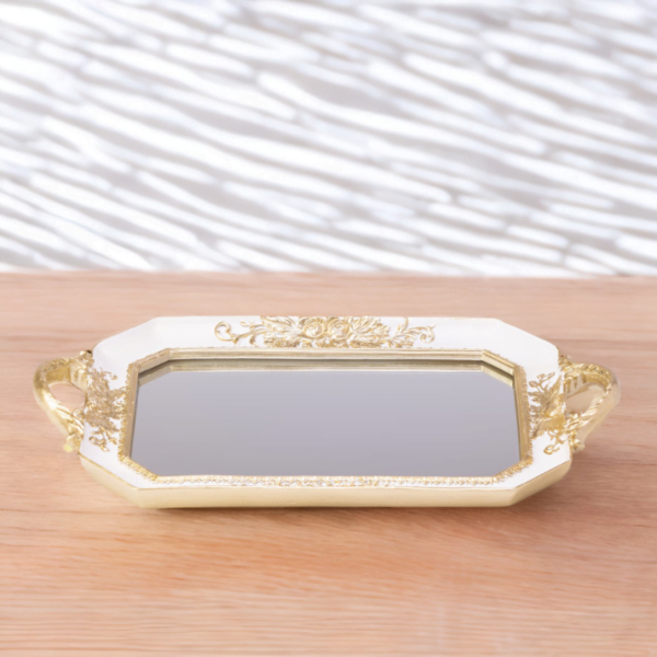An ornate white octagon tray with a mirror bottom and gold accents.