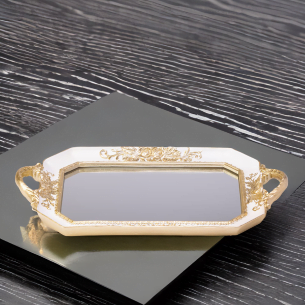 An ornate and white octagon tray with a mirror bottom and gold accents.