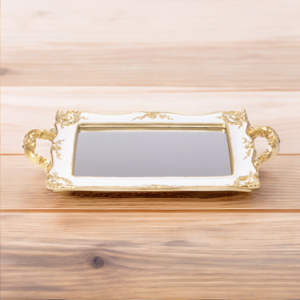 A white tray with Mirror bottom and gold accents on a wood surface.