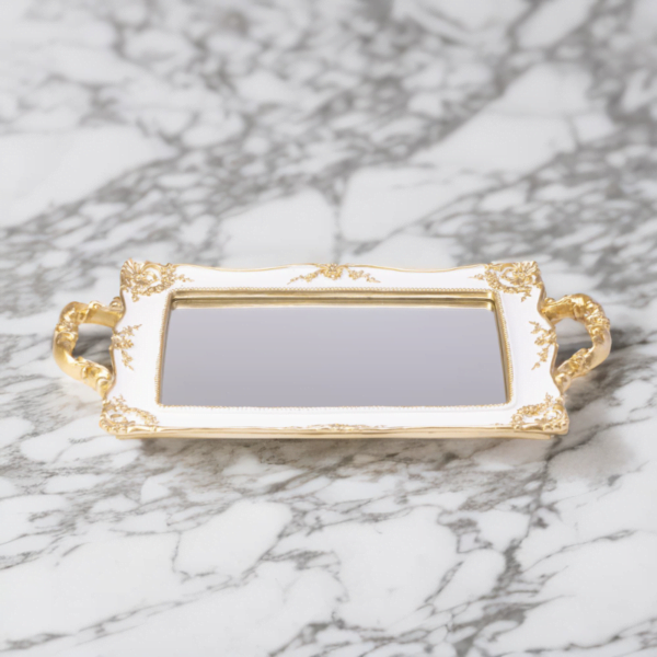 A white tray with Mirror bottom and gold accents on a marble surface.