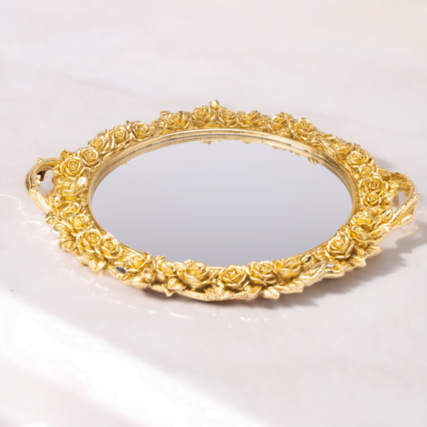 An ornate gold mirror on top of a marble Flower Tray.