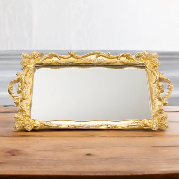 An ornate golden Tray (Rahaf Tray) with mirror bottom on a wooden surface.