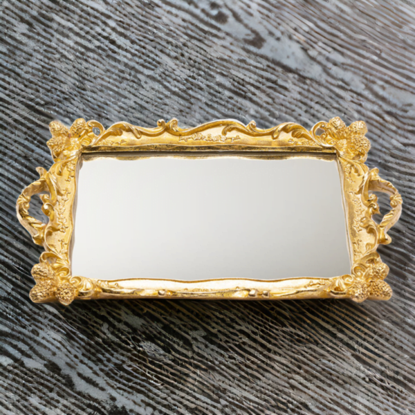 An ornate golden Tray (Rahaf Tray) with mirror bottom on a wooden surface.