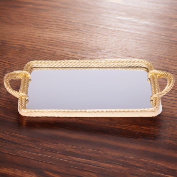 A gold mirror tray with twisted metal styling on a wooden table.