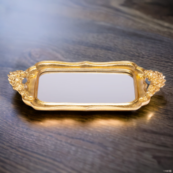 A gold rectangular Fancy Tray on a wood surface.