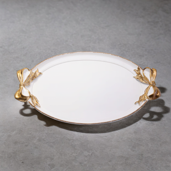 A Ribbon Tray with gold handles on a grey surface.