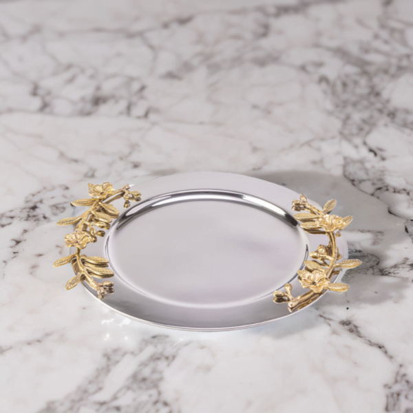 Alia stainless steel tray styled with gold leaves on a marble surface.