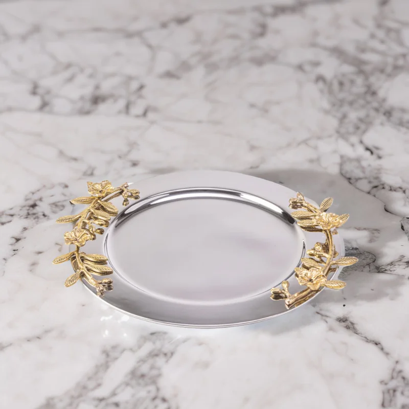 Alia stainless steel tray styled with gold leaves on a marble surface.