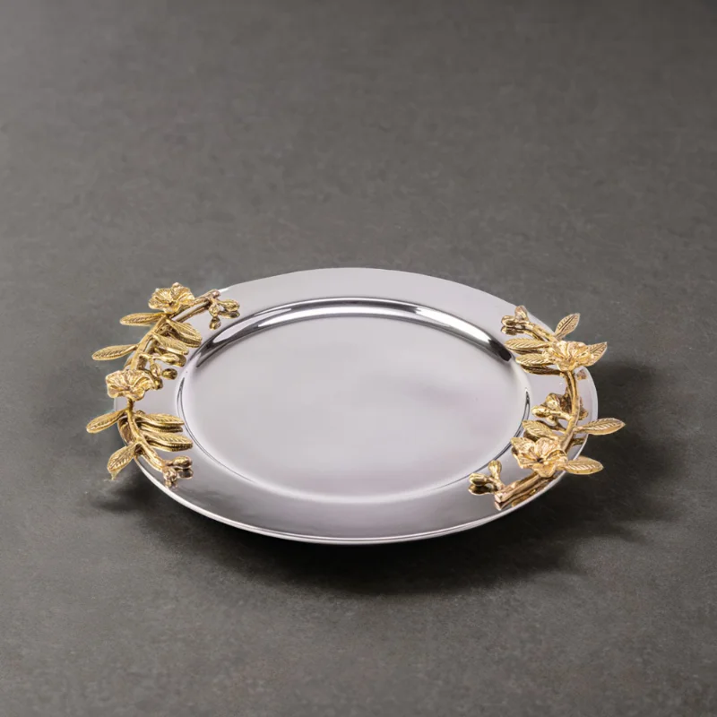 Alia stainless steel tray styled with gold leaves on a grey surface.