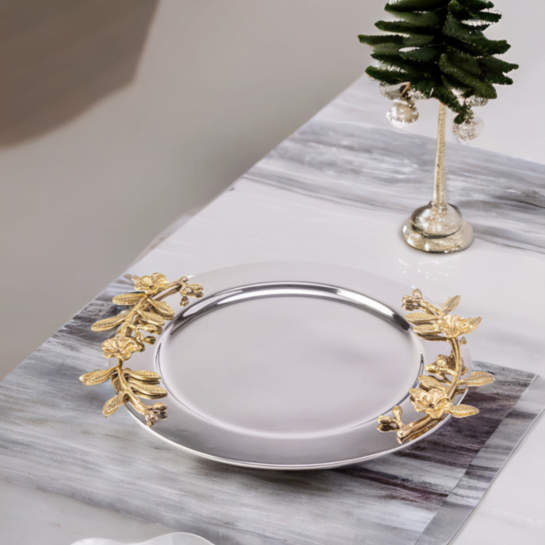 Alia stainless steel tray styled with gold leaves on a dining table.