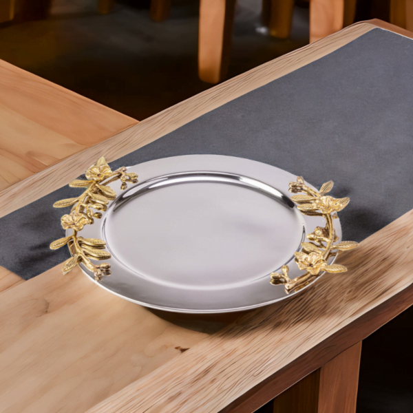 Alia stainless steel tray styled with gold leaves on a wooden table.