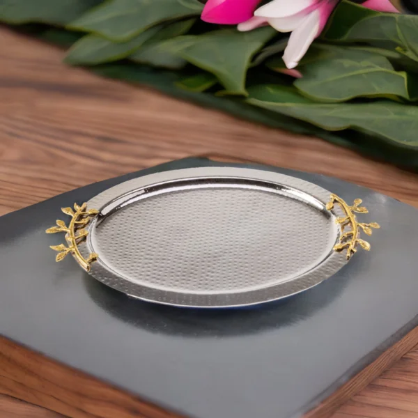 A gold and silver Leaf Oval Tray with flowers next to it.